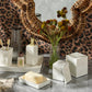 White Navagio Bath Collection accessory set featuring a soap pump, soap dish with soap, toothbrush holder, and lidded canisters on a tray, all crafted from spiraled burl resin.