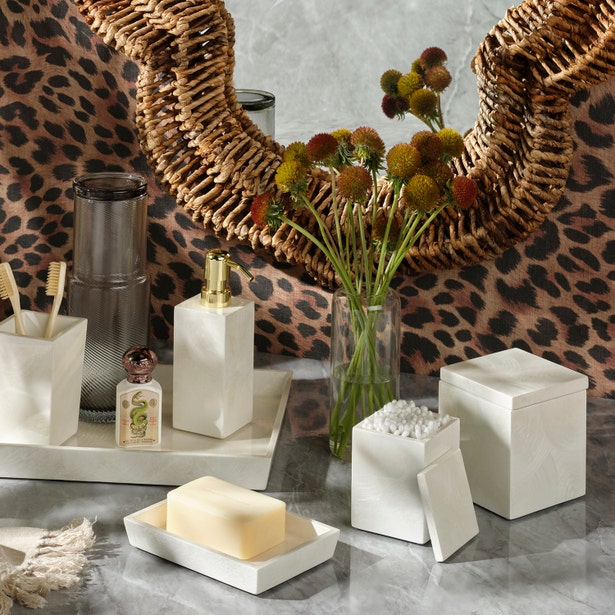 White Navagio Bath Collection accessory set featuring a soap pump, soap dish with soap, toothbrush holder, and lidded canisters on a tray, all crafted from spiraled burl resin.