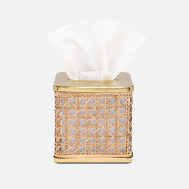 The Pigeon & Poodle Norwell Bath Collection features a woven rattan tissue box with elegant lines and a gold metal top, displaying white tissues through its opening.