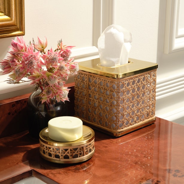 A tissue box, soap dish with bar soap, and vase with pink flowers from the Pigeon & Poodle Norwell Bath Collection sit on a polished marble countertop by a white wall with gold trim, highlighting their sophisticated silhouettes.