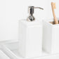 The Rothwell Bath Collection by Pigeon & Poodle features a white, water-resistant soap dispenser with a silver pump and matching toothbrush holder, both crafted from durable yacht leather for a luxurious look.