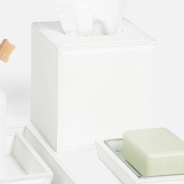 From the Rothwell Bath Collection by Pigeon & Poodle: a white water-resistant yacht leather tissue box holder with tissues, a soap dish with a pale green bar of soap, and a toothbrush on the left side.