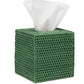 The Dalton Bath Collection by Pigeon & Poodle features a green tissue box holder with a woven pattern, crafted with detailed workmanship and organic dyes. A white tissue elegantly emerges from the top.