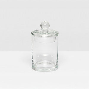 The Darby Clear Canister Collection by Pigeon & Poodle features a clear glass container with a round lid and knob, ideal as a bathroom organizer or for versatile storage throughout your home.