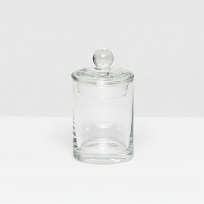 The Darby Clear Canister Collection by Pigeon & Poodle features a clear glass container with a round lid and knob, ideal as a bathroom organizer or for versatile storage throughout your home.