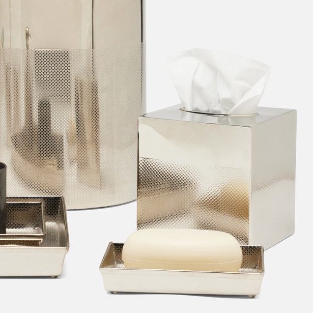 The Pigeon & Poodle Hagen Bath Collection includes silver accessories like a tissue box holder, soap dish with soap, and sleek black cup on a tray. Made of shiny nickel, these pieces add modern sophistication to any decor.