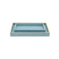 Two rectangular blue trays from the Pigeon & Poodle Manchester Bath Collection, featuring beige veneer trim and a subtle natural eye pattern, with the smaller tray nested inside the larger one, displayed on a white background.