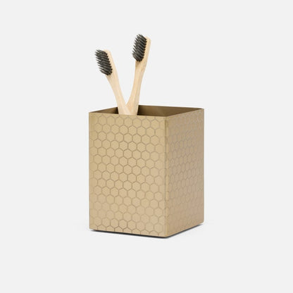 The Temara Honeycomb Bath Collection by Pigeon & Poodle features a gold toothbrush holder with a stylish honeycomb pattern, holding two wooden toothbrushes with dark bristles, set against a plain white background.