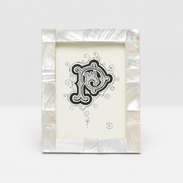 The Lesina Frame Collection by Pigeon & Poodle showcases a decorative black and white letter "P" on white paper in a white kabibe shell frame with mother-of-pearl border, ideal for bringing coastal elegance to your décor.