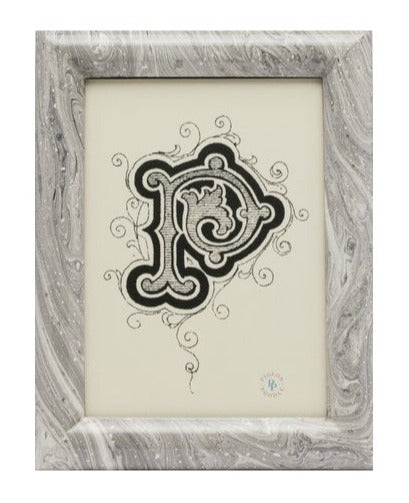 A monochrome ornamental letter "p" illustrated in a baroque style, centered on a cream background, framed by a Pigeon & Poodle Gray Swirled Lacquered Resin Ashland Frame, 5 x 7.