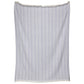 The Lavanya Throw Collection by John Robshaw showcases a light blue and white striped cotton textile with a subtle herringbone weave, fringed top and bottom, displayed against a white background.