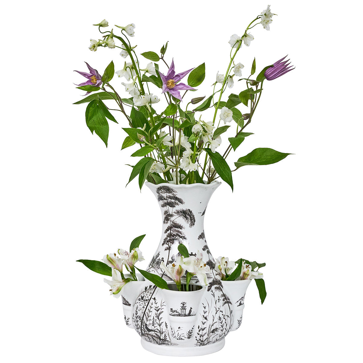 The Juliska Flint Grey Country Estate Tulipiere Vase features black botanical designs and side pockets, beautifully displaying green leaves with white and purple flowers for a refined country estate floral look.