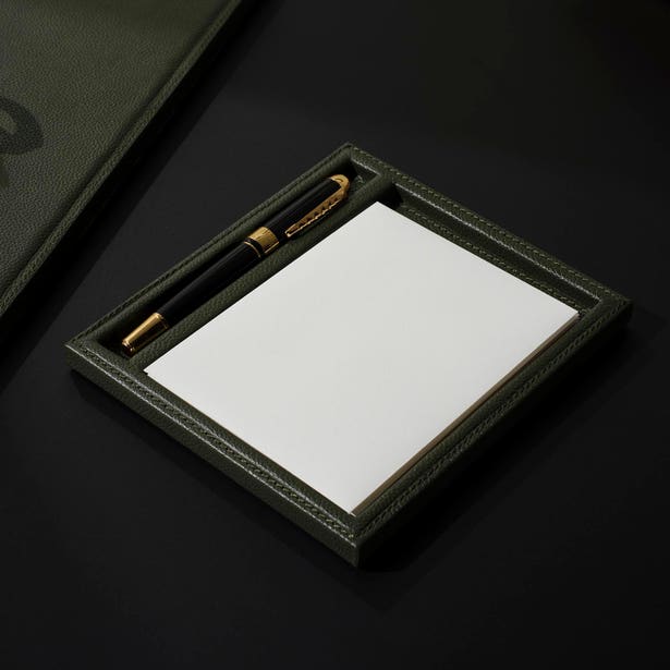 Olive green full-grain leather Grafton Laptop Desk Blotter Set Collection desk tray containing a notepad and a black-and-gold pen.