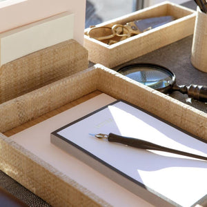 The Koba Natural Grass Desk Accessory Set by Pigeon & Poodle, featuring a pen on a notepad with a magnifying glass, scissors, and envelopes nearby, adds a retro 70s vibe to your workspace.