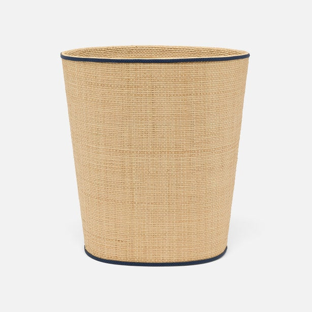 The Hanford Desk Accessory Collection by Pigeon & Poodle features a beige woven raffia wastebasket with black trim on the top and bottom, shown against a plain white background.