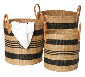 The Pigeon & Poodle Hudson Basket Set includes three striped baskets with tan leather handles; one tall basket neatly holds a folded white towel.