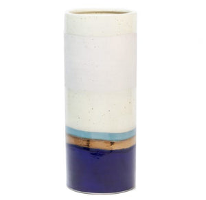 The Lienz Umbrella Stand by Pigeon & Poodle features a tall, cylindrical ceramic design with horizontal white, light blue, tan, and deep blue bands—ideal as a decorative accent or striking umbrella holder in any entryway.