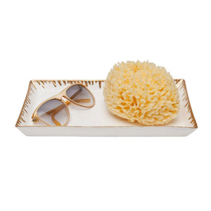 The Rio Tray Collection by Pigeon & Poodle is a chic white porcelain tray with gold metallic drip trim, perfect for holding sunglasses and a sea sponge as part of your decorative trays collection.