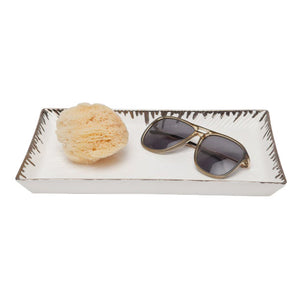The Rio Tray Collection by Pigeon & Poodle features a rectangular white porcelain tray, perfect for holding a natural sea sponge and sunglasses, adding a stylish accent to your decor.