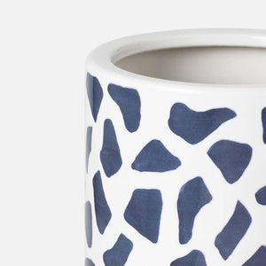 A close-up of the Pigeon & Poodle Yuba Umbrella Stand, featuring white ceramic with irregular blue geometric patterns and a hand-applied print on its surface.