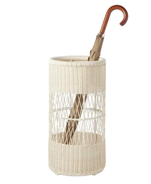 The Winburg Umbrella Stand by Pigeon & Poodle features a white faux rattan design that stylishly holds a single umbrella with a curved wooden handle, ideal for drying.