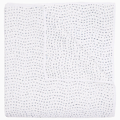 A folded white coverlet from the John Robshaw Hand-Stitched Bedding Collection, featuring small, evenly spaced black stitches in a wavy pattern across soft cotton voile fabric.