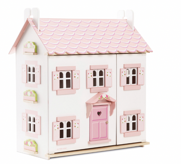 An imaginative play Wooden Dolls House with pink shutters.