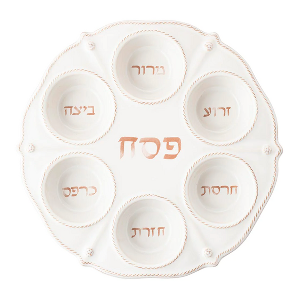 The Juliska Berry & Thread Classic Whitewash Seder Plate by Juliska features a modern design with a fluted silhouette and six sections, each labeled in Hebrew for traditional Passover foods such as maror and charoset, arranged in a circular pattern to add a contemporary touch to the celebration.