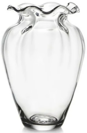 The Simon Pearce Chelsea Optic Cinched Vase, expertly crafted by skilled glassblowers, showcases a clear glass design with a wavy, fluted top and a tapered base, embodying the elegance typical of Simon Pearce's creations.