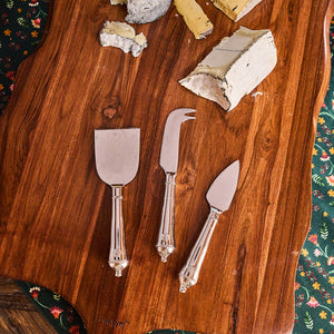 The Juliska Berry & Thread Polished Cheese Knife Set features three elegant cheese knives with ornate handles, perfect for serving assorted cheeses—an essential for any cheese lover.