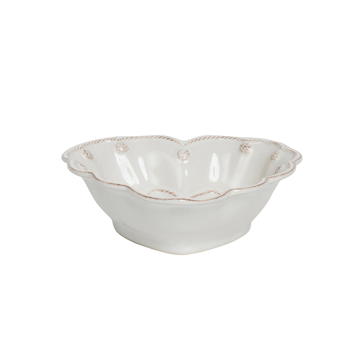 Juliska's Berry & Thread Whitewash Heart Serveware Collection features a white ceramic bowl with a ruffled rim and decorative detailing, inspired by the signature Berry & Thread design, shown against a plain background.
