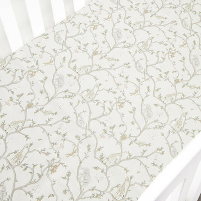 The Gooselings Animal Parade Ivory Crib Sheet is an extra soft cotton sateen sheet for crib mattresses, featuring a delicate pattern of neutral-tone animal designs.