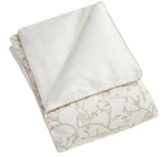 The Gooselings Animal Parade Ivory Toddler Duvet is a folded, lightweight duvet with a white top and pastel animal-and-tree patterned underside—ideal as a toddler duvet or down insert.