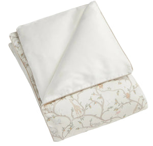 The Gooselings Animal Parade Ivory Toddler Duvet is a folded, lightweight duvet with a white top and pastel animal-and-tree patterned underside—ideal as a toddler duvet or down insert.