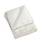 The Gooselings Animal Parade Ivory Bedding Collection features a folded comforter with a crisp white side and another adorned with delicate branches and playful animals—perfect for inspiring sweet dreams in children's rooms.