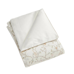 The Gooselings Animal Parade Ivory Bedding Collection features a folded comforter with a crisp white side and another adorned with delicate branches and playful animals—perfect for inspiring sweet dreams in children's rooms.