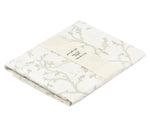 Folded Gooselings Animal Parade Ivory Swaddle, made from 100% cotton with a subtle animal and branch pattern, wrapped in a paper band displaying product and sizing details.