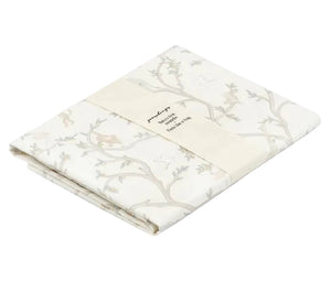 Folded Gooselings Animal Parade Ivory Swaddle, made from 100% cotton with a subtle animal and branch pattern, wrapped in a paper band displaying product and sizing details.