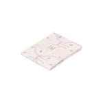 A folded, light pink 100% cotton Gooselings Bows & Butterfly Kisses - Swaddle with floral and bow prints, wrapped in a cream paper band showing the product label and care instructions.