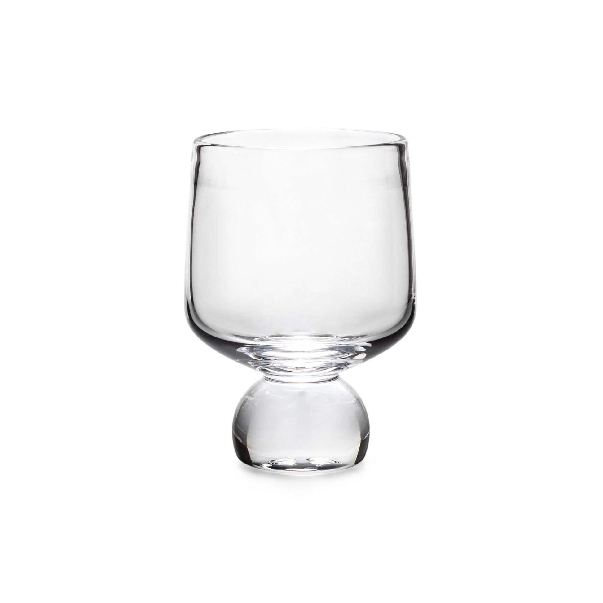 The Simon Pearce Benson Drinkware Collection features a clear glass cup with a wide bowl and rounded base, photographed on white, highlighting its clean lines inspired by Bauhaus simplicity.