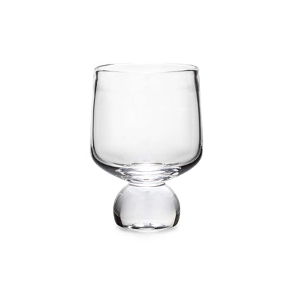 The Simon Pearce Benson Drinkware Collection features a clear glass cup with a wide bowl and rounded base, photographed on white, highlighting its clean lines inspired by Bauhaus simplicity.
