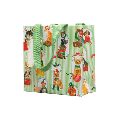 The Presenting Pets Collection gift bag by Caspari features green and white stripes with festive dog illustrations and green handles—ideal for pairing with disposable tableware or elegant paper plates at your next celebration.