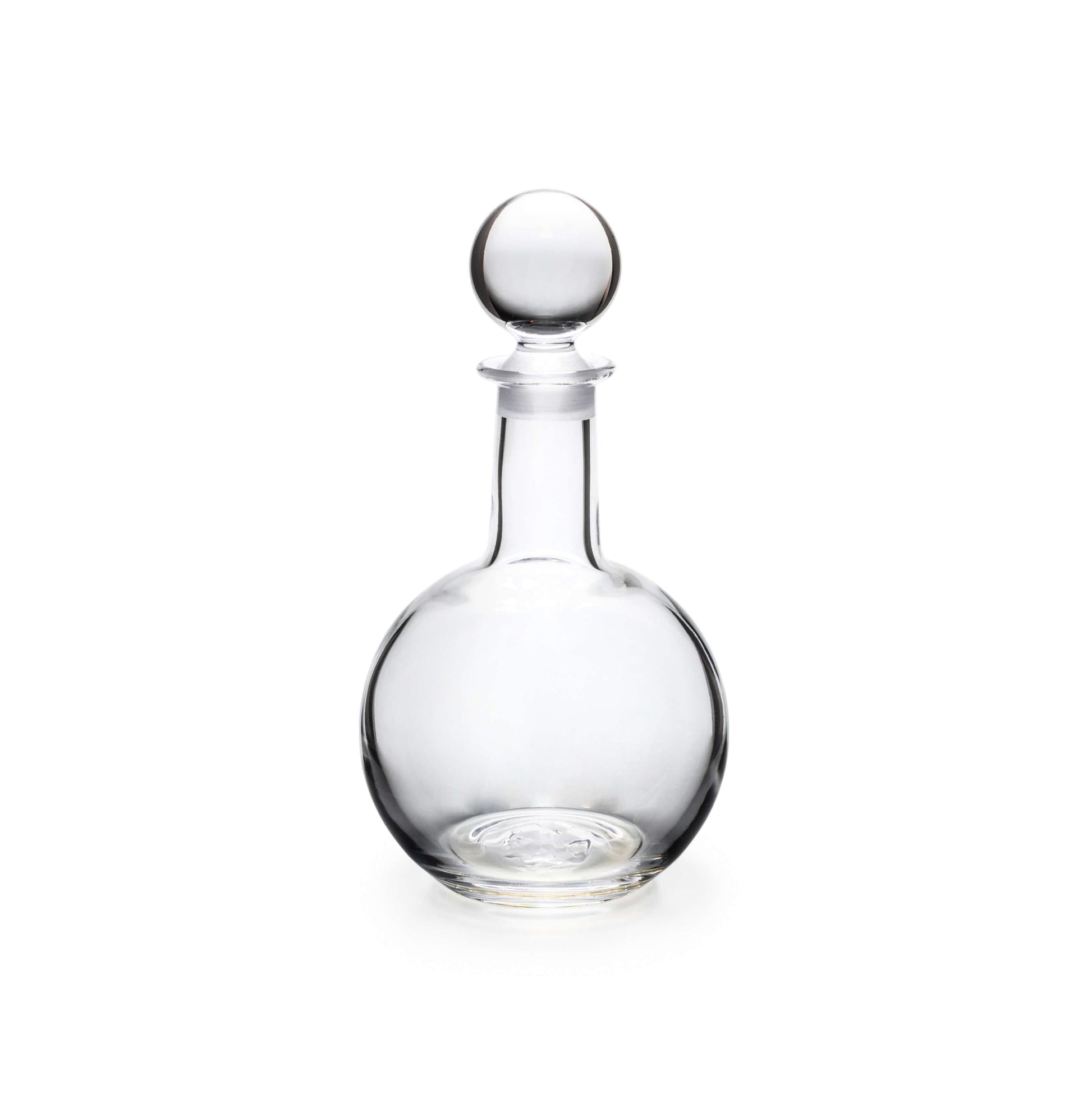 The Benson Drinkware Collection by Simon Pearce features a clear glass decanter with a round stopper and clean-lined Bauhaus-inspired design, elegantly photographed against a white background.