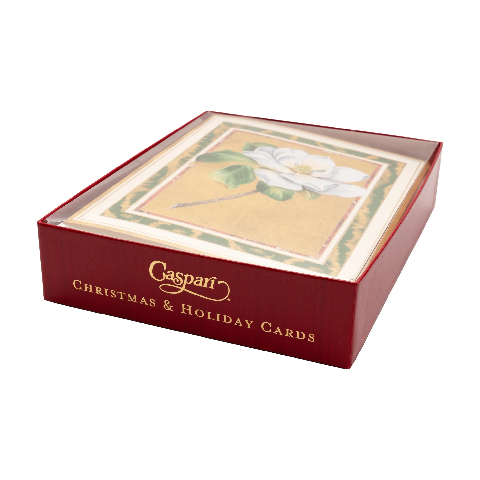 A red Caspari box labeled "Magnolia Bloom Boxed Card Set" holds Christmas cards with a white magnolia flower design, all visible under a clear lid.