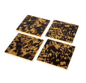 The Caspari Tortoiseshell Lacquer Coaster Set includes four glossy, dark brown and yellow coasters, beautifully displayed on a white background and ready for your favorite coaster holder.