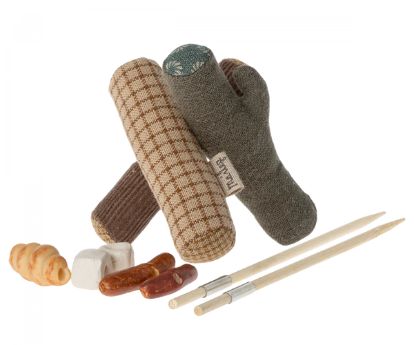A variety of Maileg Bonfire Set camping toys for dogs and treats arranged against a black background.