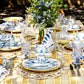 A table set outdoors with Delft Blue china, glassware, silverware, flowers, a yellow striped cloth, and Juliska Country Estate Place Card Holders as elegant accents for each guest.