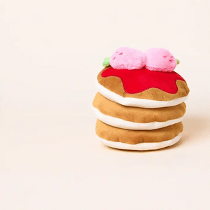 The Foggy Dog’s Strawberry Pancake Interactive Dog Toy features a plush stack of pancakes topped with red syrup and two pink berries, set against a plain background.
