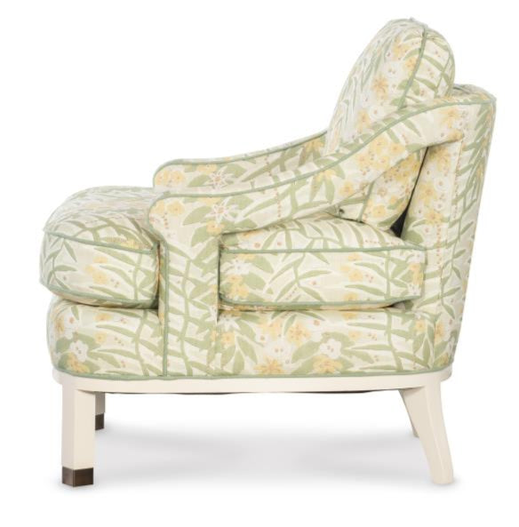 Side view of the Highland House Atchison Slipper Chair, upholstered in Botanical Citron fabric with a green and yellow floral leaf pattern, featuring cushioned seat, back, and arms atop smooth white wooden legs.