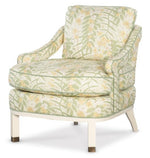 The Atchison Slipper Chair by Highland House features Botanical Citron fabric in green, yellow, and white floral patterns, a cushioned seat and back, smooth white wooden legs, and brass-capped feet.